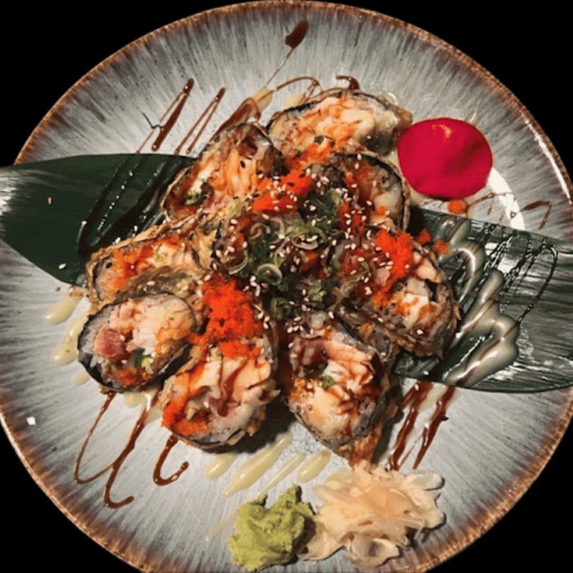 Katsumori Asian Fusion's fried sushi rolls with orange tobiko, sesame seeds, and sauces on a plate.