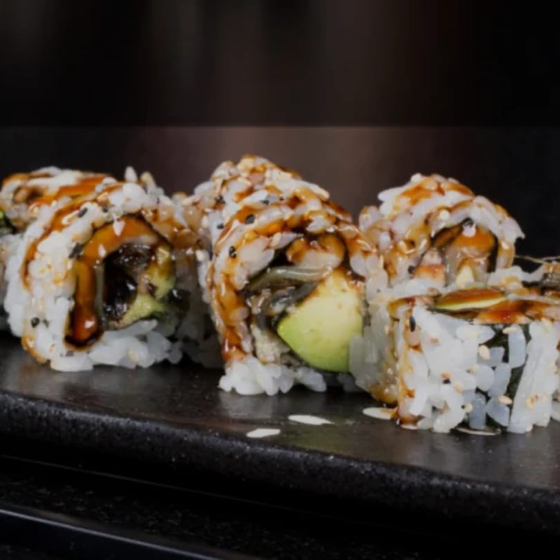 Katsumori Asian Fusion sushi rolls with avocado, eel, and sesame seeds, drizzled with sauce.