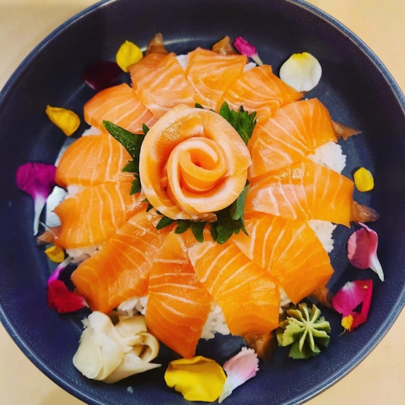 Katsumori Asian Fusion's salmon sashimi arranged like a rose, surrounded by rice and edible flowers.